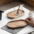 Wooden trays on a table with a glass of water and a spoon.